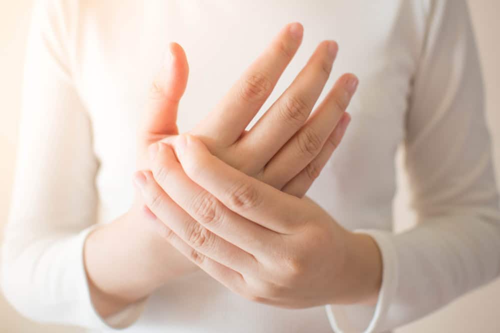 Young Female In White T-shirt Suffering From Pain In Hands